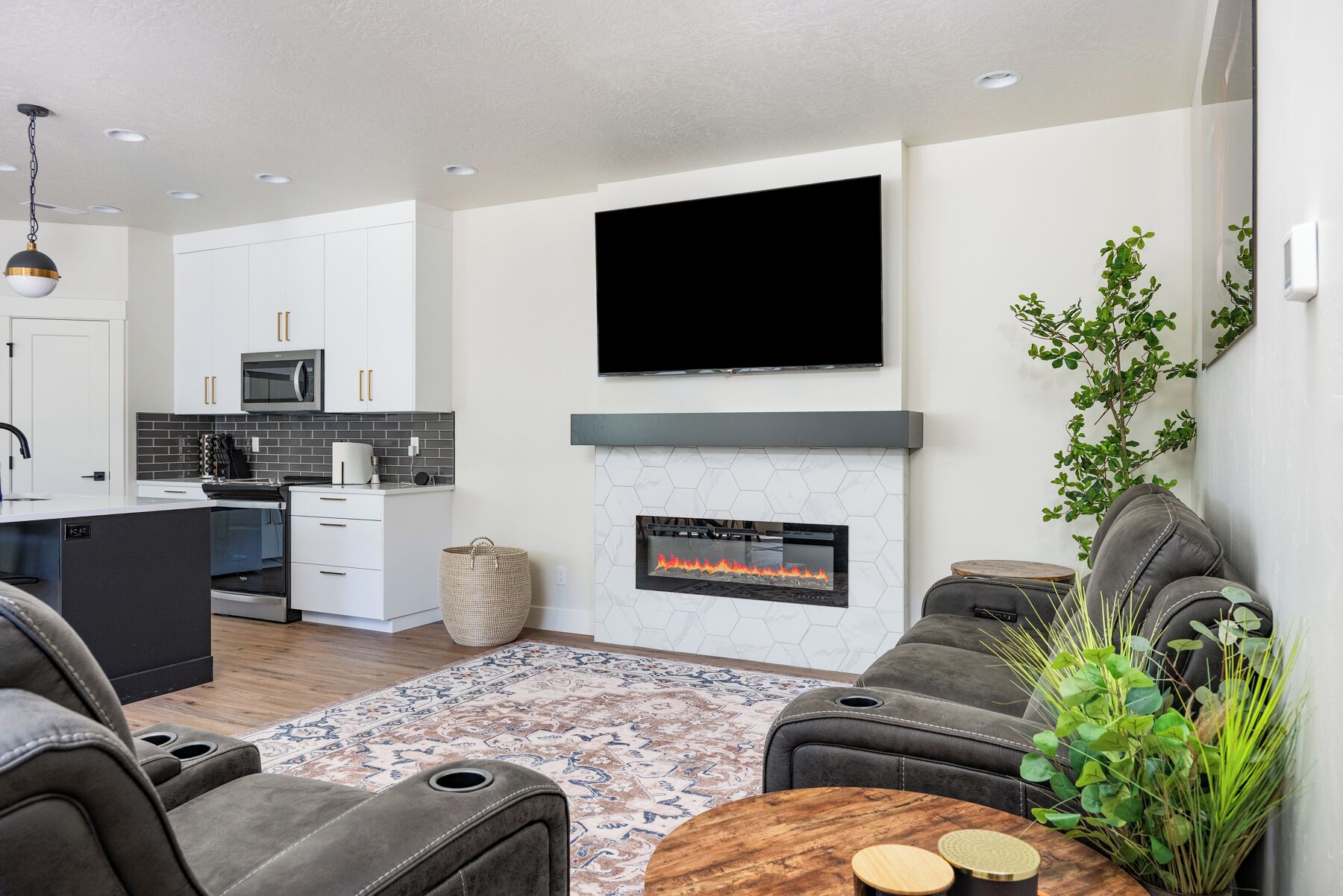 Una sala de estar moderna con chimenea, un televisor de pantalla plana montado encima, un sofá y una mesa de centro.
