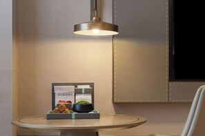 A round table with a lamp, a framed picture, and a small plant. - Yelang Hotel (Hezhang)
