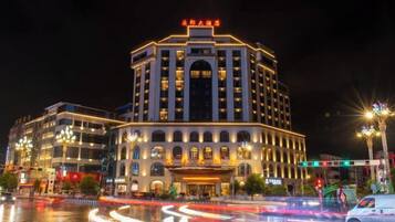 A multi-story hotel with a prominent entrance and illuminated signage.