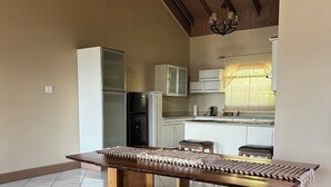A modern kitchen with white cabinets, a built-in refrigerator, and a wooden ceiling. - 2BR Hip Strip•Ocean View Balcony•Steps to Beach (Montego Bay)