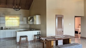 A spacious kitchen with a large island, wooden ceiling beams, and a modern chandelier. - 2BR Hip Strip•Ocean View Balcony•Steps to Beach (Montego Bay)
