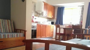 Un soggiorno con divano, tavolo da pranzo in legno e un piatto decorativo con una stella marina.