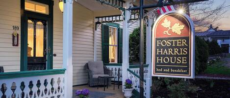 Une véranda avec une enseigne indiquant « Foster Harris House », proposant des services de chambre d’hôtes et de petit-déjeuner.