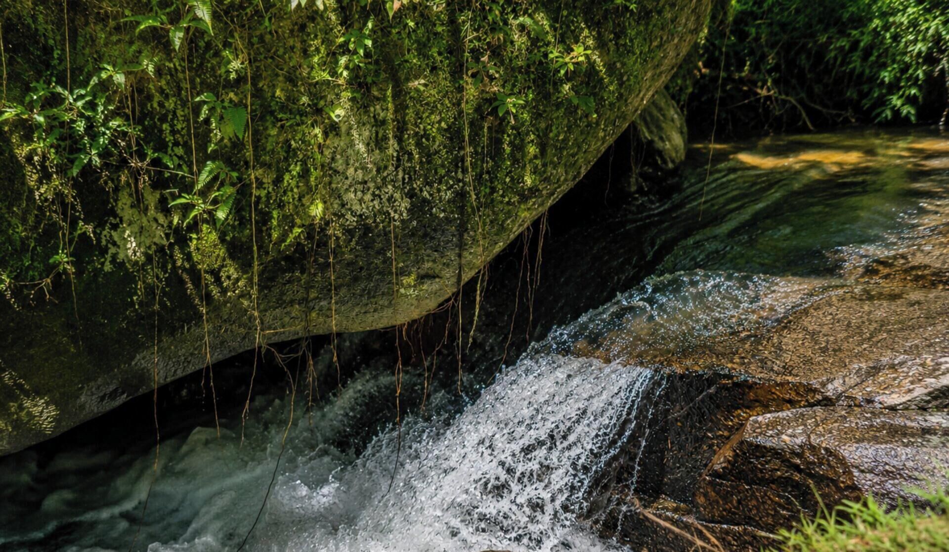 Formación rocosa natural con una pequeña cascada.