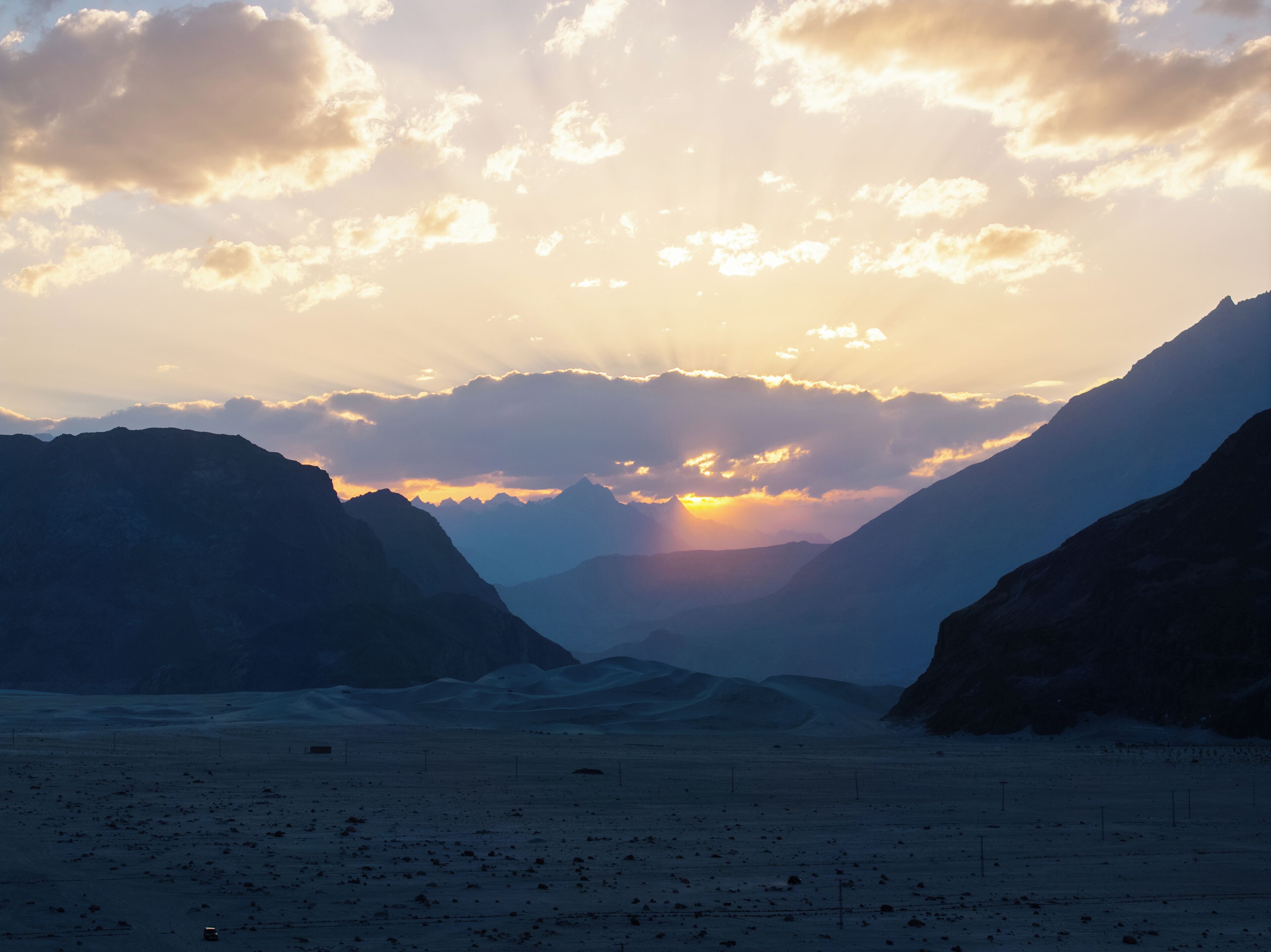 A mountainous landscape with a valley and distant mountains.