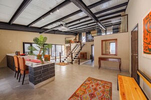 Un amplio espacio de estar con una isla de cocina, una escalera y un gran ventanal.