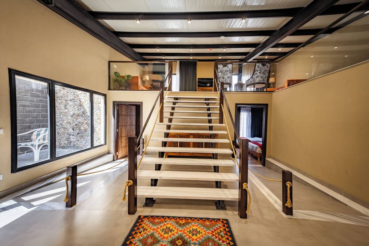 A staircase with wooden steps and a handrail, leading to a second floor.