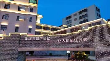 A multi-story building with illuminated signage and a brick facade.