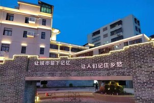 Un edificio de varios pisos con señalización iluminada y fachada de ladrillo.