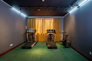 A room with two treadmills, a stationary bike, and a green carpet. - Vienna International Hotel (Yunfu City Center Yihua Plaza) (Yunfu)