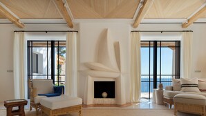 A spacious living room with a fireplace, large windows, and a view of the sea. - Sea front! Wonderfull villa with sea views from every room. (Capdepera)
