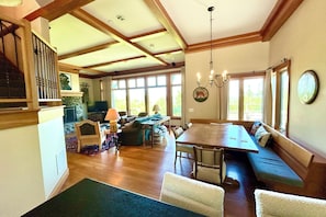 A spacious living area with a wooden dining table, a sofa, and a fireplace.