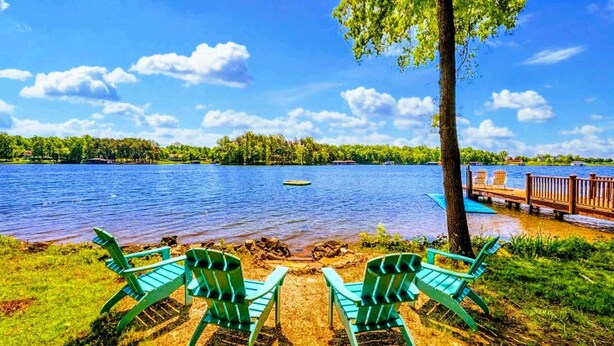 A lakeside view with chairs and a dock. - Lakefront Log Cabin at Lake Anna, Dock, Deck (Bumpass)