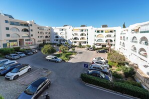 Stylish residential building with balconies and large windows, set amidst a well-manicured environment.