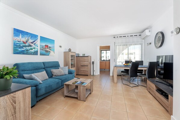 Relax in a spacious living area with a comfortable sofa and dining space for meal preparation.