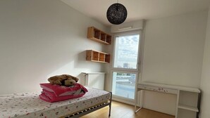 A bedroom with a single bed, a window with a view, a radiator, and a hanging light fixture. - The cytadin! Pied streetcar paris porte de choisi 11 minutes, Palais Royal musé 45 min (Vitry-sur-Seine)