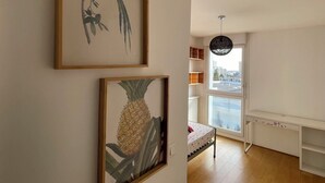 A room with a bed, a window with a view, and two framed botanical prints on the wall. - The cytadin! Pied streetcar paris porte de choisi 11 minutes, Palais Royal musé 45 min (Vitry-sur-Seine)