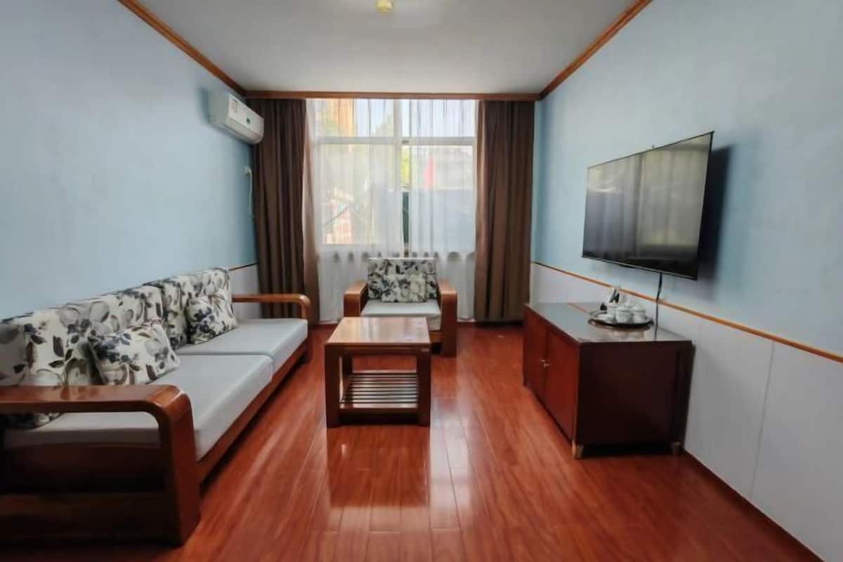 A room with a sofa, a coffee table, a TV, and a cabinet.