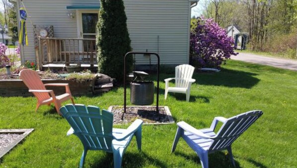 A grassy yard with outdoor seating, a fire pit, and a small shed. - Charming 3B/R Cottage on Malletts Bay (Colchester)