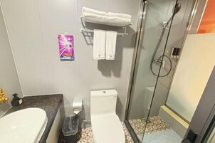 Un baño con ducha, inodoro y lavamanos.