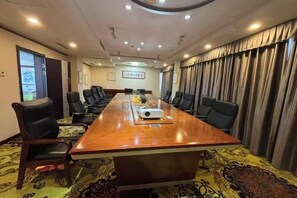 A conference room with a long table, chairs, and a projector. - Hot Spring Holiday Hotel (Nanpi)