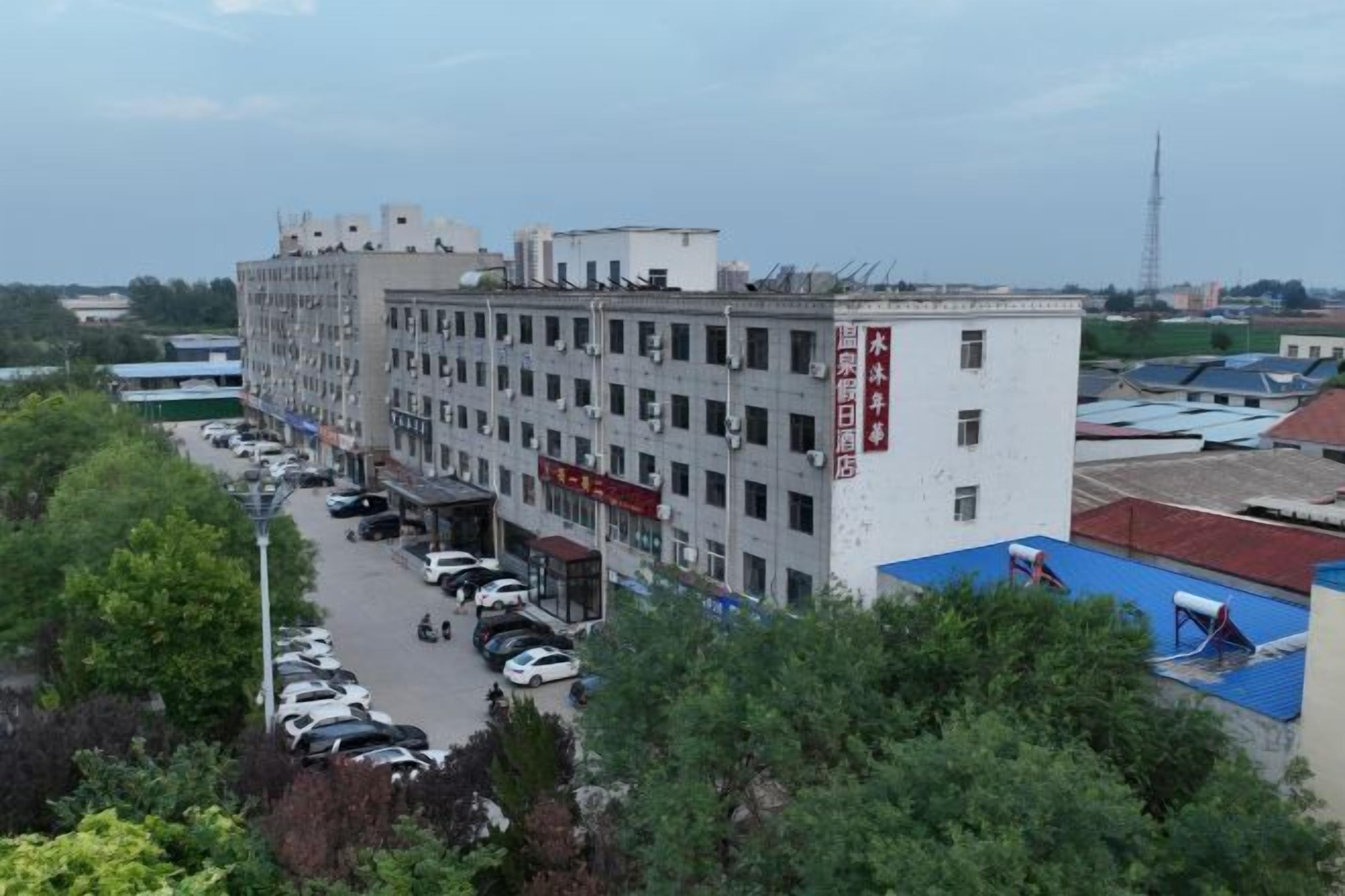 A multi-story building with a parking lot in front.