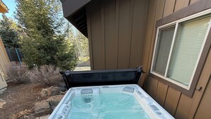 Un bain à remous équipé d’un panneau de commande, d’une marche et d’une fenêtre.