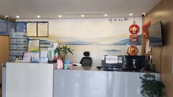 A reception desk with informational posters, a computer, and a television.
