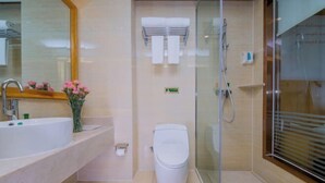 A modern bathroom with a glass shower enclosure, a white toilet, and a sink with a mirror above it. - Vienna Hotel (Wuhan Central China Normal University, Huquan Metro Station) (Wuhan)