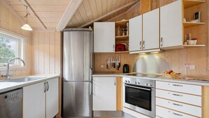 A modern kitchen with stainless steel appliances, wooden cabinets, and a window providing natural light. - Gorgeous home in Slagelse with WiFi (Slagelse)
