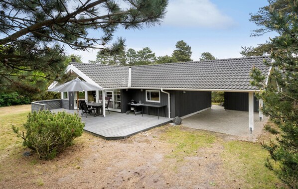 A modern house with a covered patio, a deck, and a large window overlooking the yard. - Gorgeous home in Slagelse with WiFi (Slagelse)