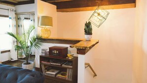 Ein gemütliches Wohnzimmer mit einer Holzbücherregal, einem Vintage-Radio und einer Pendelleuchte.
