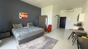 Un dormitorio moderno con una cama grande, un escritorio y una silla.