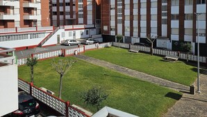 Een woongebouw met meerdere verdiepingen, balkons en een parkeerplaats.