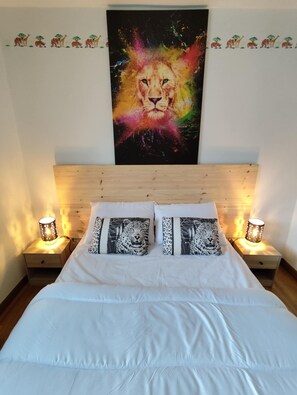 A bedroom with a large painting of a lion on the wall, a wooden headboard, white bedding, and two bedside lamps. - Chez Nanou 50 meters from the port!  Magnificent vacation home (Le Tréport)