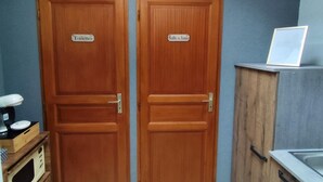Cocina compacta con dos puertas de madera identificadas como “Toilettes” y “Salle de Bain”, una encimera con lavabo y un tragaluz.