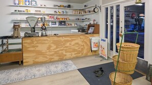 A small shop with a wooden counter, shelves with various items, a clock, and baskets near the entrance. - 1 bedroom nice apartment in Kvås (Kvås)