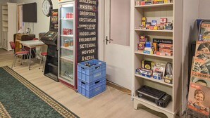 A room with a vintage jukebox, a refrigerator stocked with beverages, a clock, and a shelf with various items including books and magazines. - 1 bedroom nice apartment in Kvås (Kvås)