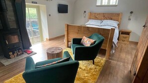 Un dormitorio estilo loft con cama, televisor y chimenea.