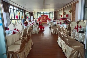 A banquet hall with rows of tables and chairs, large windows, and a central aisle. - Chongqing Liandu Lake Resort (Chongqing)