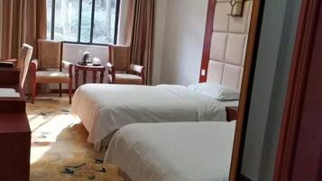 Una habitación de hotel con dos camas, un escritorio y una silla.