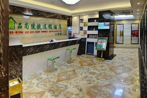 A hotel reception area with a marble floor, a reception desk, and a digital screen. - Pinshang Express Chain Hotel (Dongxing Guomen Port) (Dongxing)