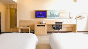 A hotel room with two beds, a desk, a chair, a television, and a wall-mounted artwork. - Pinshang Express Chain Hotel (Dongxing Guomen Port) (Dongxing)