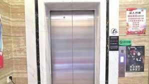 An elevator with a metallic finish, a control panel with buttons, and a wall-mounted sign with text. - Pinshang Express Chain Hotel (Dongxing Guomen Port) (Dongxing)