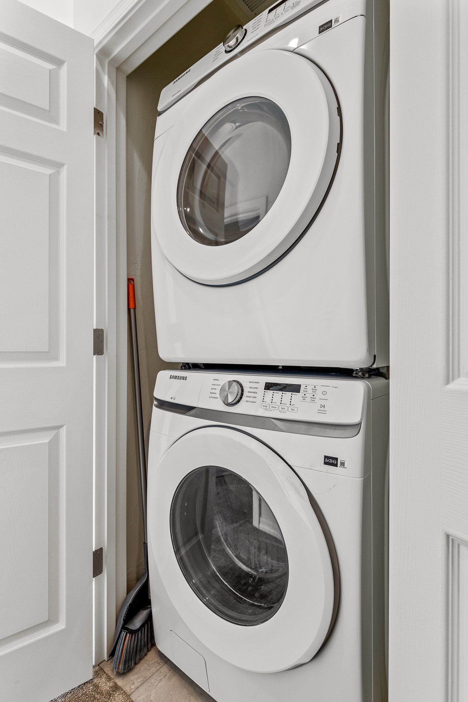 Une machine à laver et un sèche-linge superposés dans une buanderie.