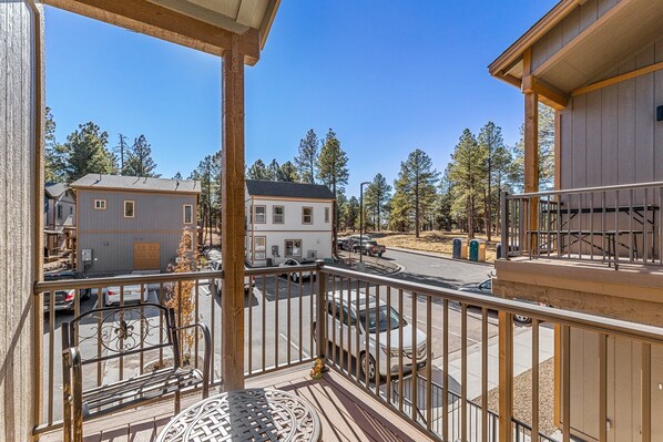 A balcony with a metal railing overlooking a street with parked cars and houses. - Butler Flagstaff (Flagstaff)
