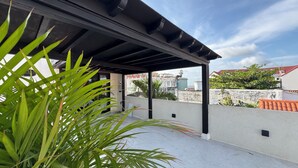 A covered outdoor area with a concrete floor and a black roof structure. - Casa Bovedas Collection by Ritzy Group (Cartagena de Indias)