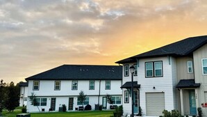 A residential building with a flat roof, multiple windows, and a garage door.