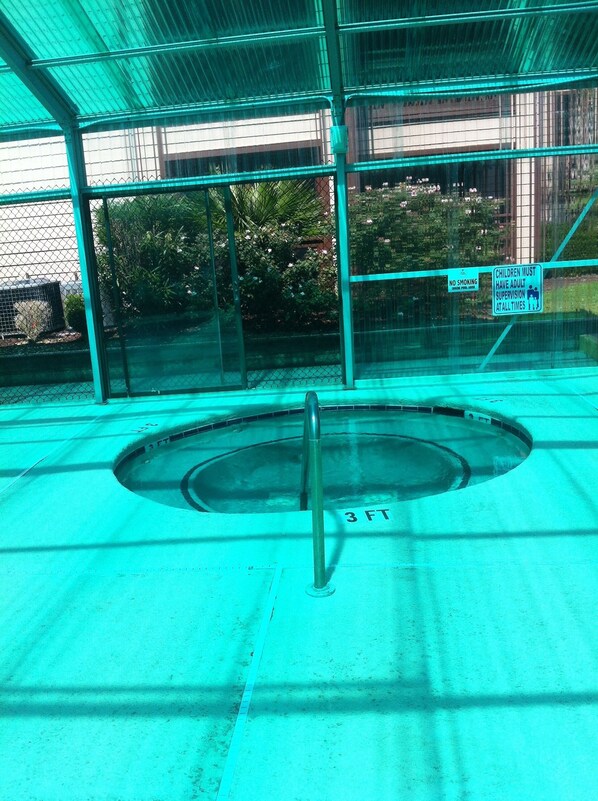 A covered swimming pool with a diving board, surrounded by a fence and a no smoking sign. - Best Little Secret in Myrtle Beach, 2 Bedroom 2 Bath Condo Ground Floor Unit (Myrtle Beach)