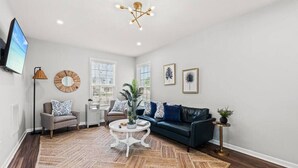 Un salon avec un canapé, une table basse et un téléviseur.